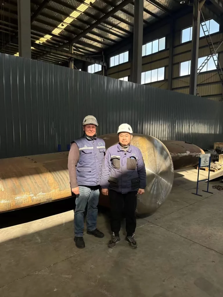 Two engineers in front of a finished rudder stock