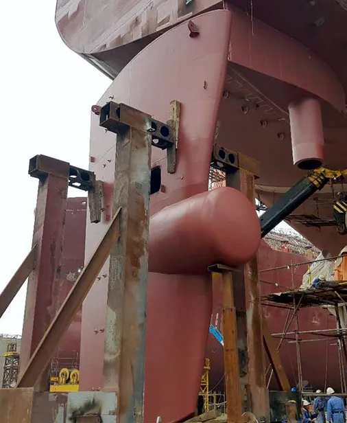 Rudder with propulsion bulb mounted on a ship hull in dry dock